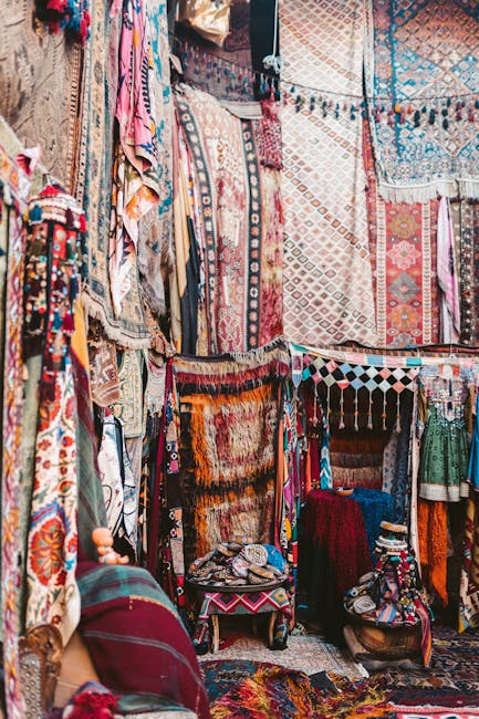 Vibrant display of traditional Turkish carpets and textiles in a lively outdoor bazaar.